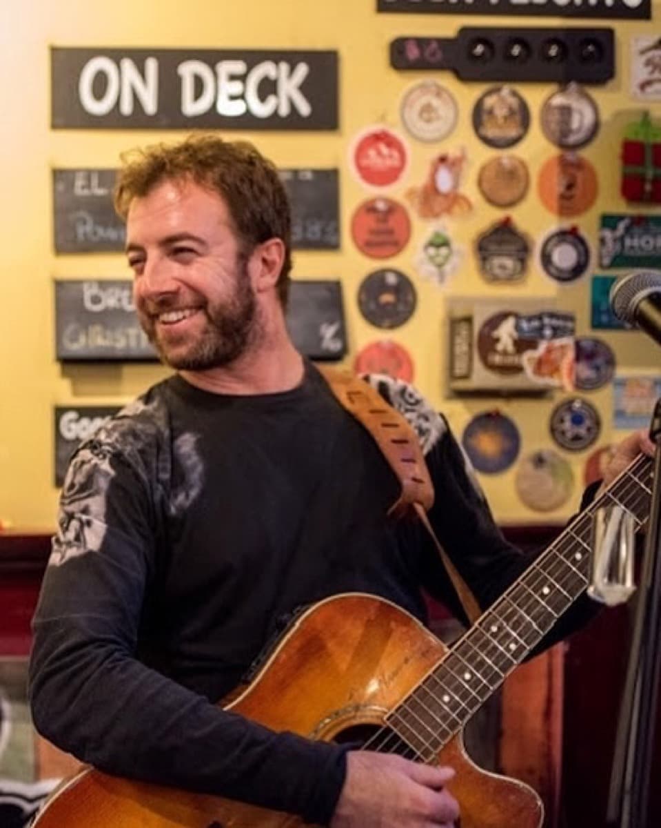 Nik Mathews performing at a bar